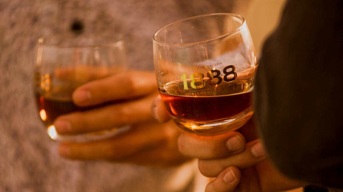 People holding glasses of premium Brugal 1888 rum