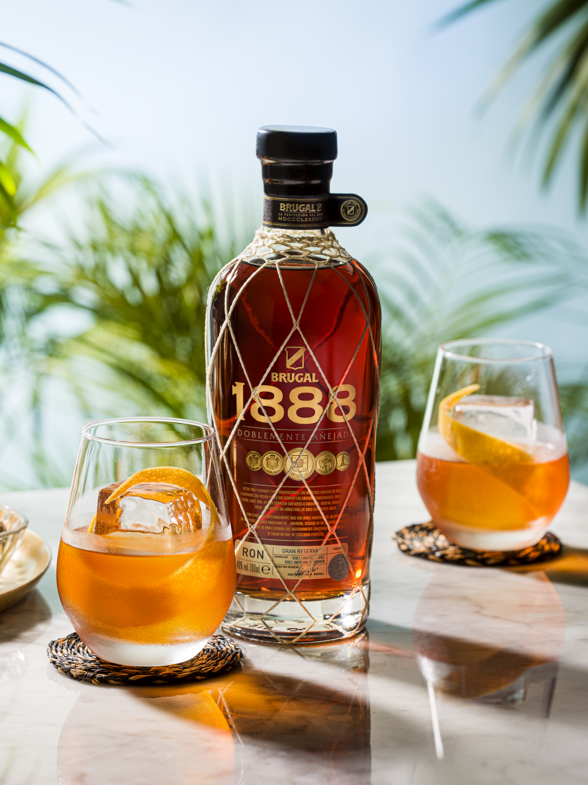 Two Negroni Sibarita cocktails accompanied by Brugal 1888 bottle