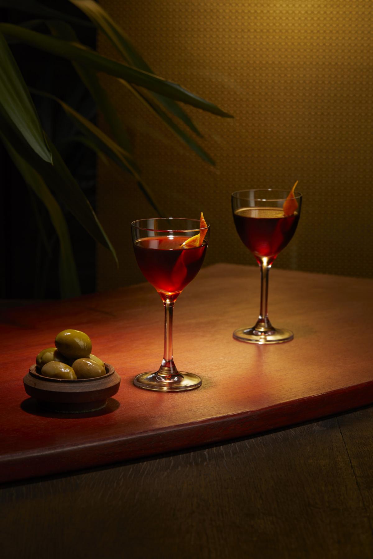 Two Dark Prince rum cocktails presented next to a bowl of olives