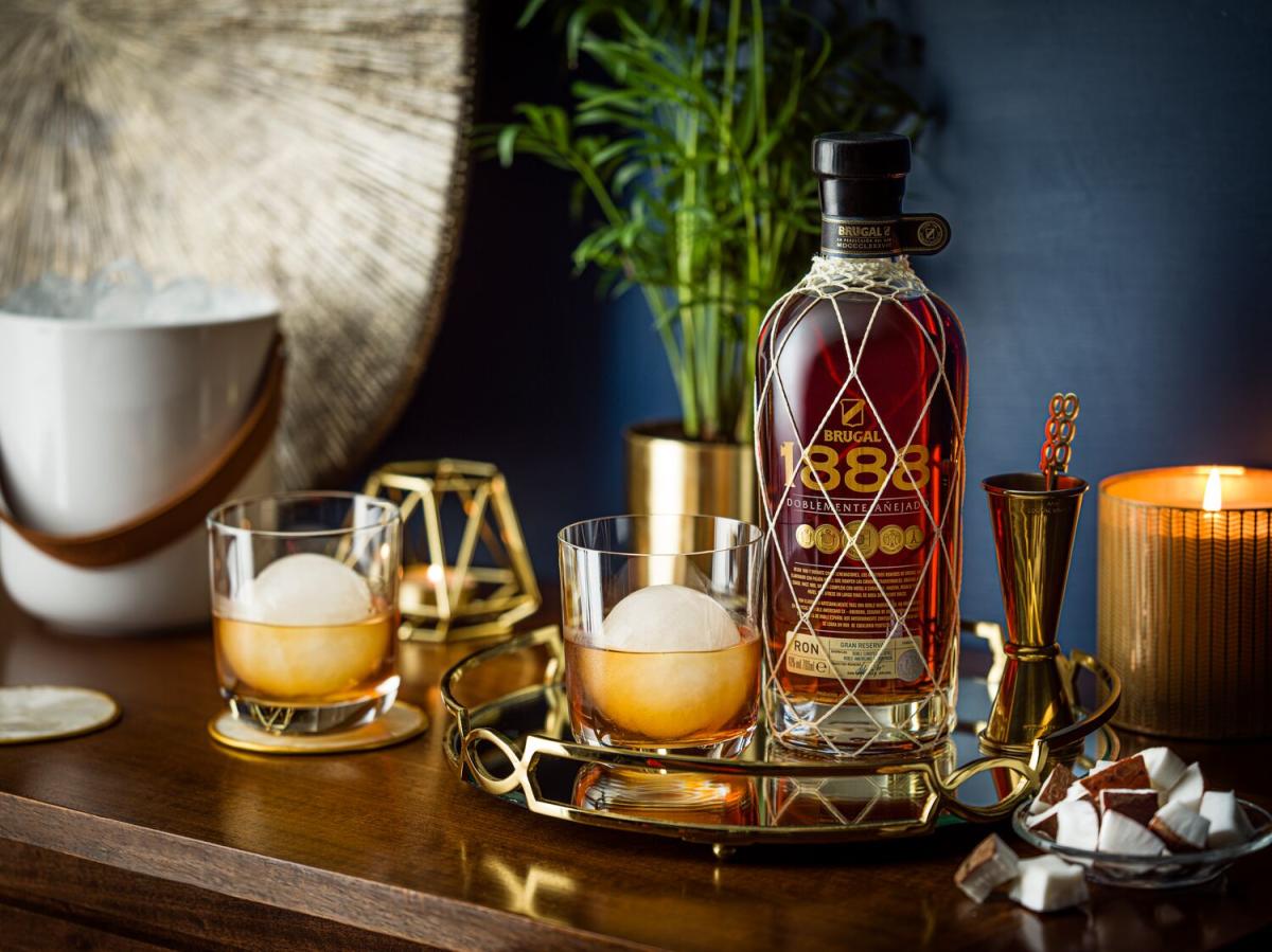 rum old fashioned with brugal bottle and coconut ice spheres
