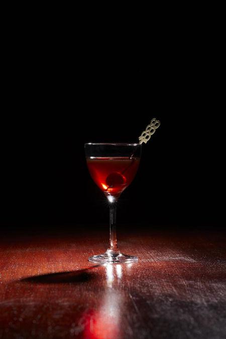Just Deserts cocktail garnished with a cherry on a decorative cocktail stick