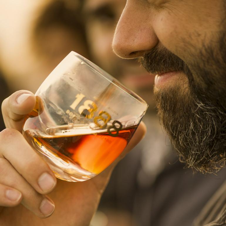 Holding nose up to glass of Brugal 1888 rum